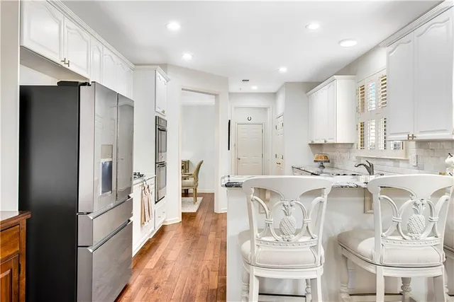 a view of a dining room and livingroom with furniture wooden floor a chandelier