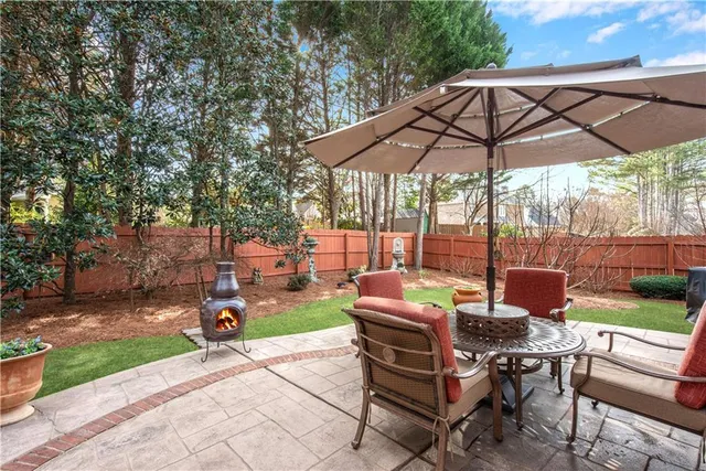 a view of a backyard with table and chairs under an umbrella