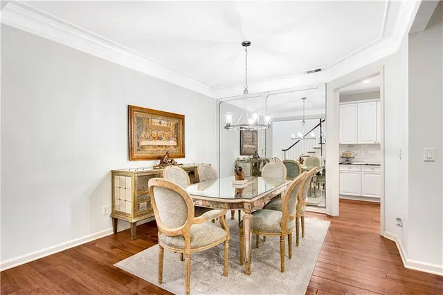 a dining room with furniture a chandelier and wooden floor
