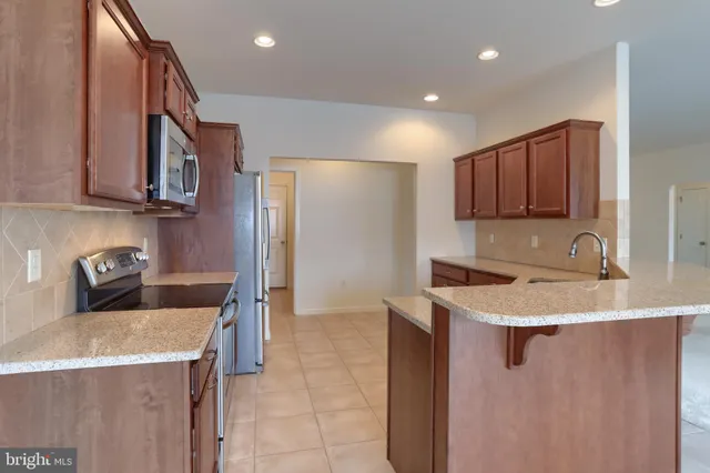 a view of a kitchen with a refrigerator and a kitchen counter top space