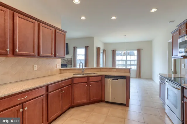a large kitchen with stainless steel appliances granite countertop a sink and stove top oven