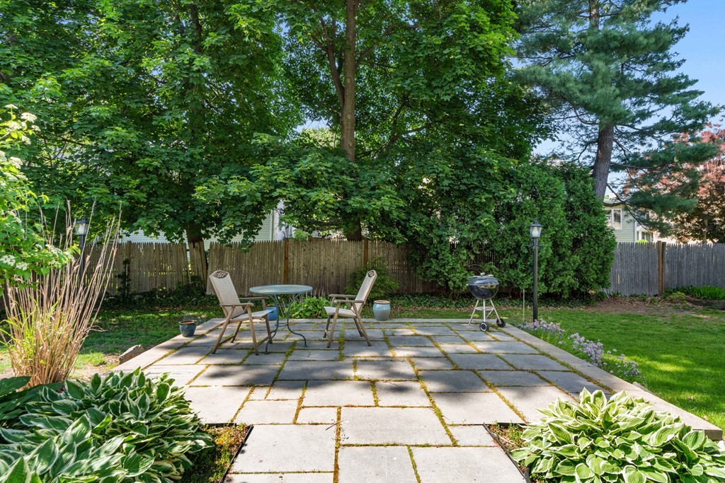 69 Statler Road Belmont, MA 02478 - Photo 31 of 34 a view of backyard with a table and chairs and potted plants