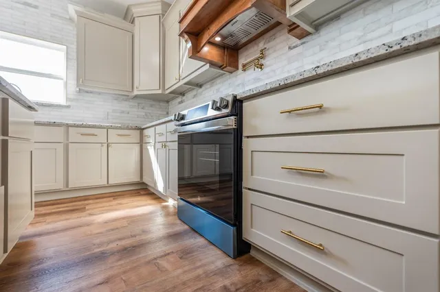 a kitchen with stainless steel appliances a sink a stove and cabinets