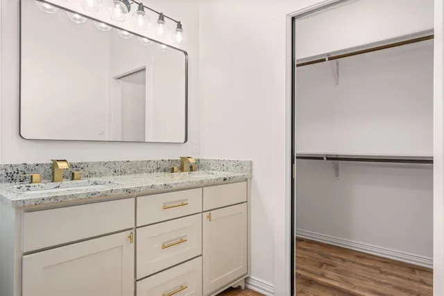 a bathroom with a granite countertop sink mirror vanity and toilet