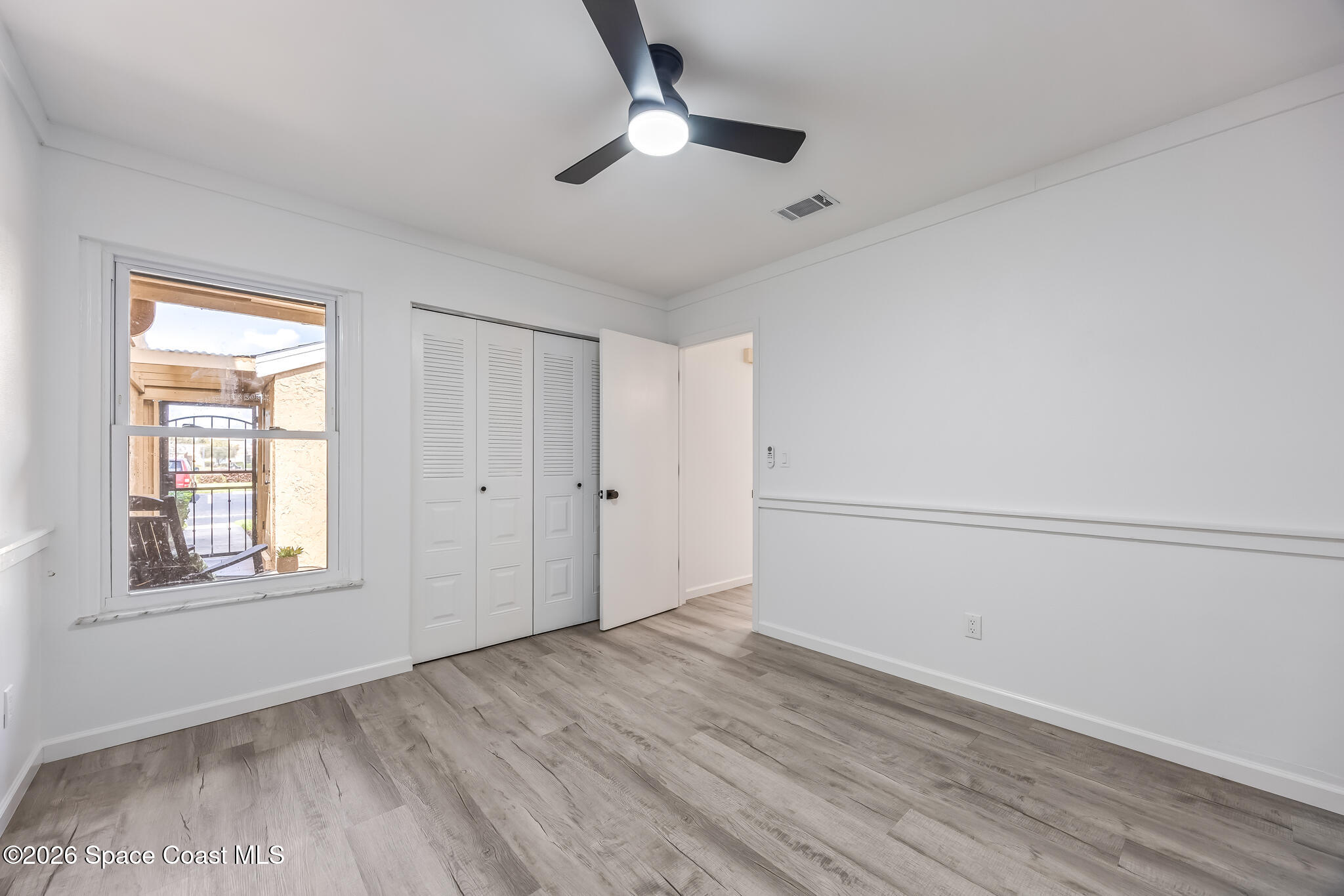 1411 Sheafe Avenue Northeast, Unit 101 Palm Bay, FL 32905 - Photo 15 of 24 a view of empty room with wooden floor and ceiling fan