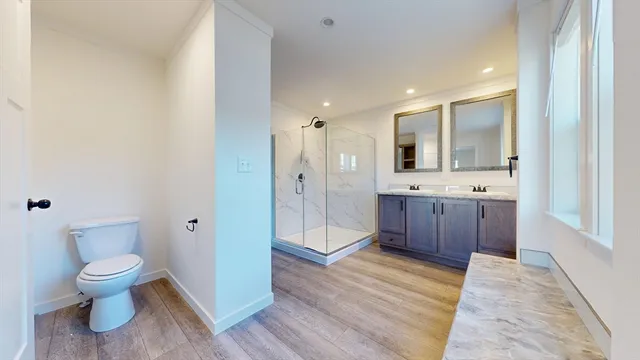 a bathroom with a sink a toilet and shower