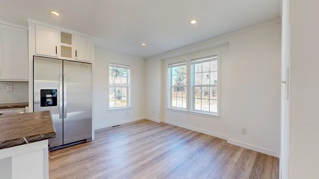 a view of an empty room with window and wooden floor