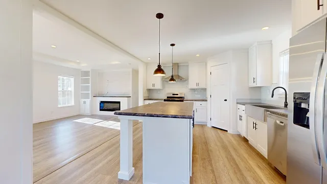 a kitchen with granite countertop a sink cabinets stainless steel appliances and a counter top space