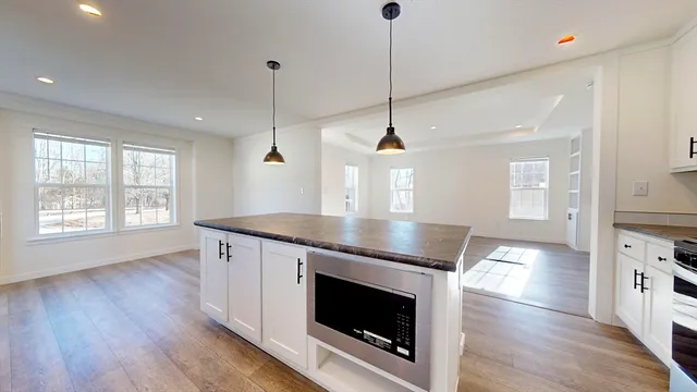 a kitchen with stainless steel appliances granite countertop a stove a sink and a wooden floor