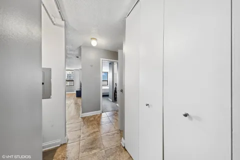 a view of a hallway with wooden floor and a bathroom