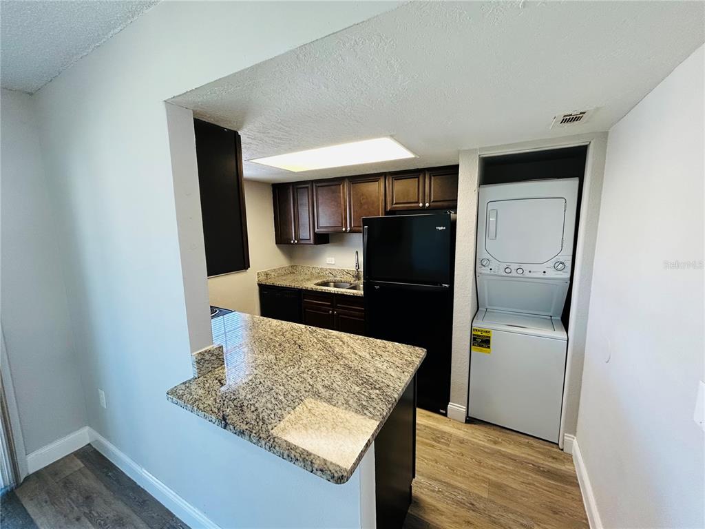 2791 L B McLeod Road, Unit D Orlando, FL 32805 - Photo 7 of 13 a kitchen with a refrigerator and a stove