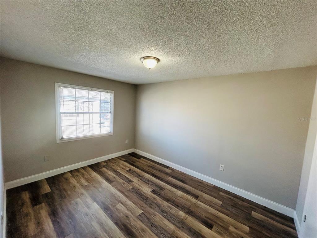 2791 L B McLeod Road, Unit D Orlando, FL 32805 - Photo 10 of 13 wooden floor in an empty room with a window