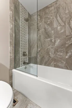 a bathroom with a sink and bathtub with toilet