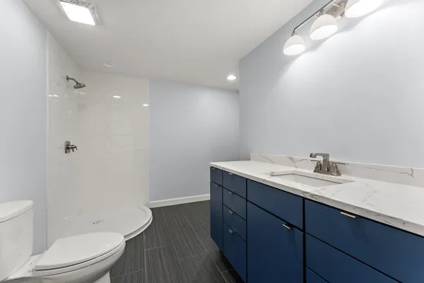 a bathroom with a granite countertop sink toilet and shower
