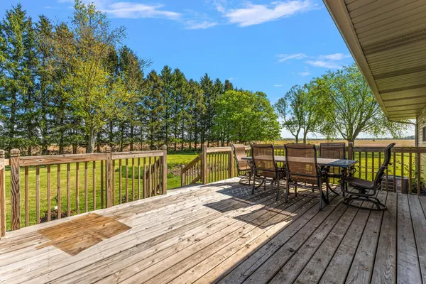 a view of a deck with chairs next to a yard