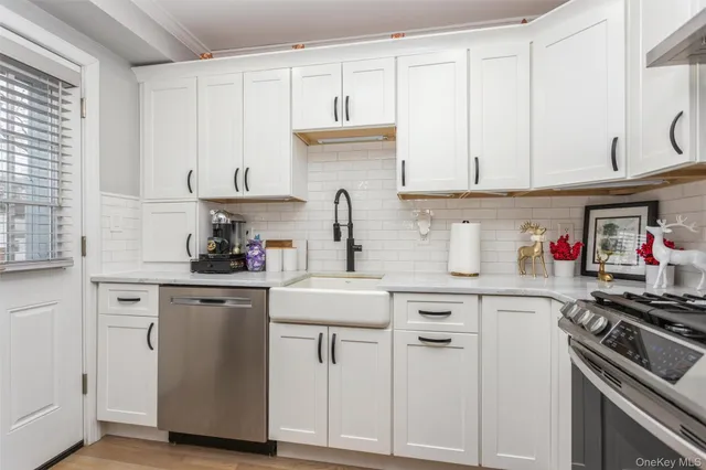 a kitchen with white cabinets and appliances