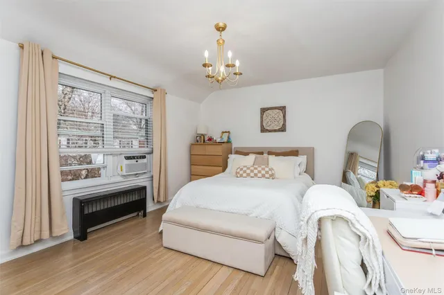 a bedroom with a bed wooden floor and window