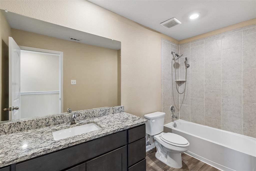 230 Enchanted Way Princeton, TX 75407 - Photo 13 of 31 a bathroom with a granite countertop sink toilet mirror and shower