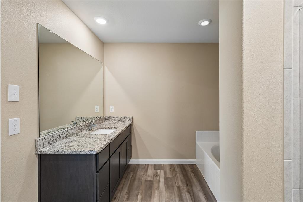 230 Enchanted Way Princeton, TX 75407 - Photo 18 of 31 a bathroom with a granite countertop sink and a mirror