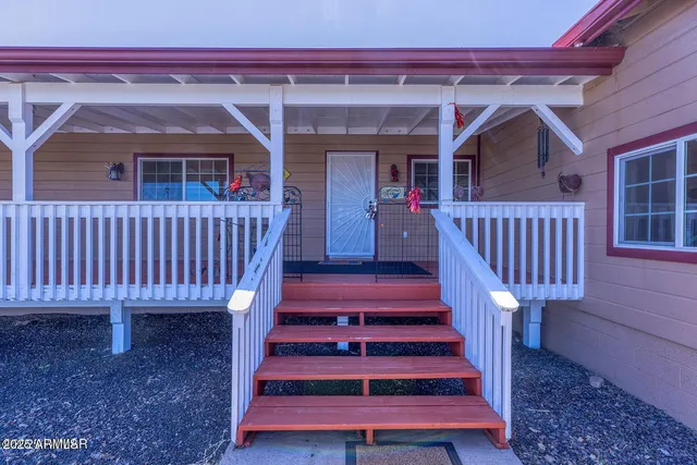 a view of a patio with table and chairs with wooden fence