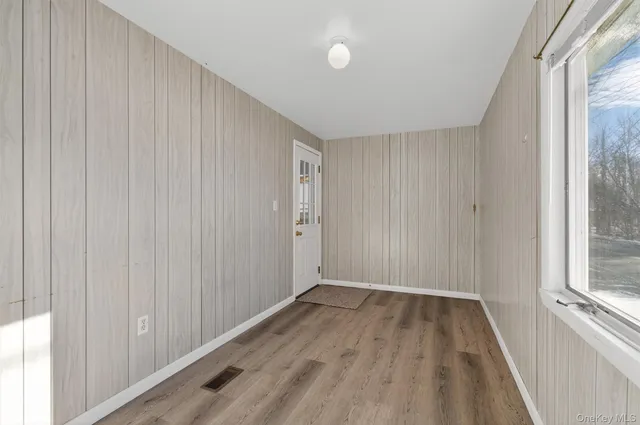 a view of a room with wooden floor and a window