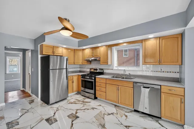 a kitchen with stainless steel appliances granite countertop a sink and a refrigerator