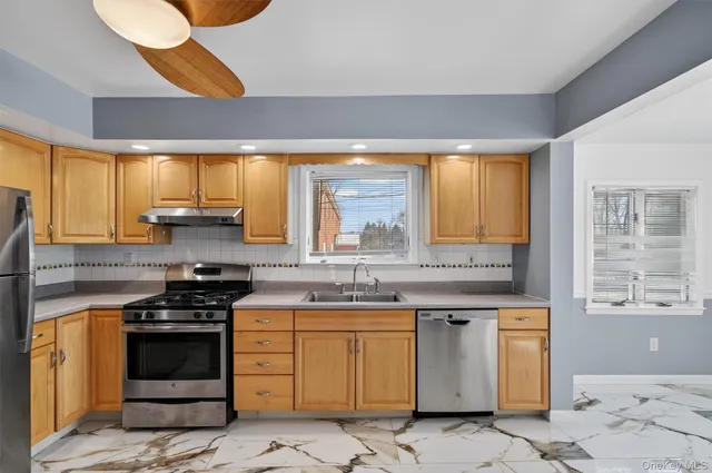 a kitchen with stainless steel appliances granite countertop a stove a sink and a microwave