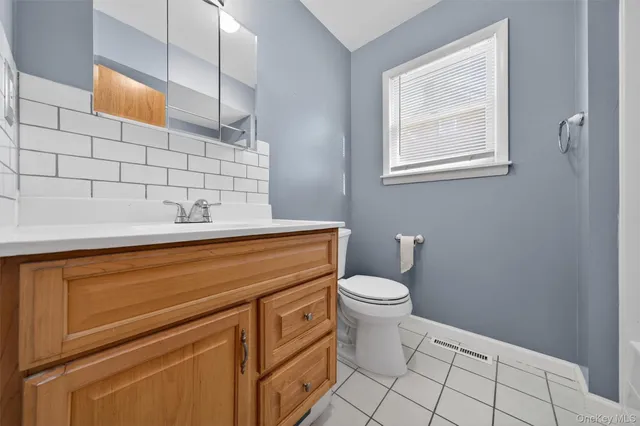 a bathroom with a toilet a sink and mirror