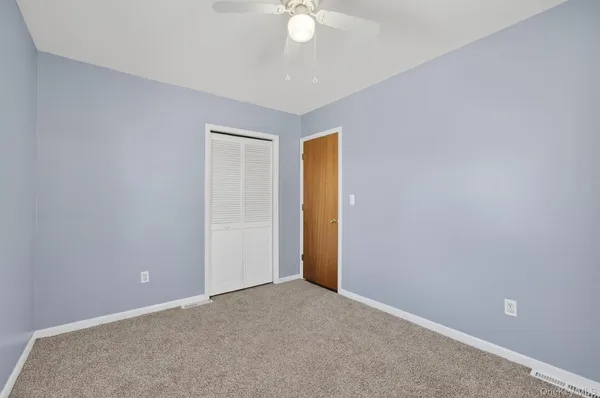 a view of an empty room and a ceiling fan