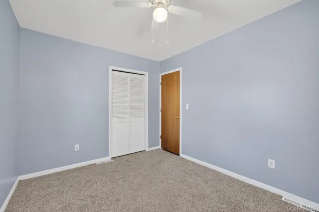 a view of an empty room and a ceiling fan