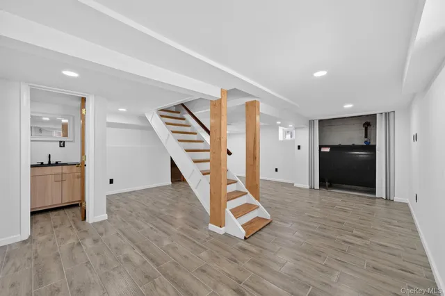 a view of empty room with wooden floor and stairs