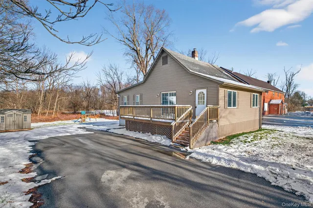 a view of a house with snow on the side of the road
