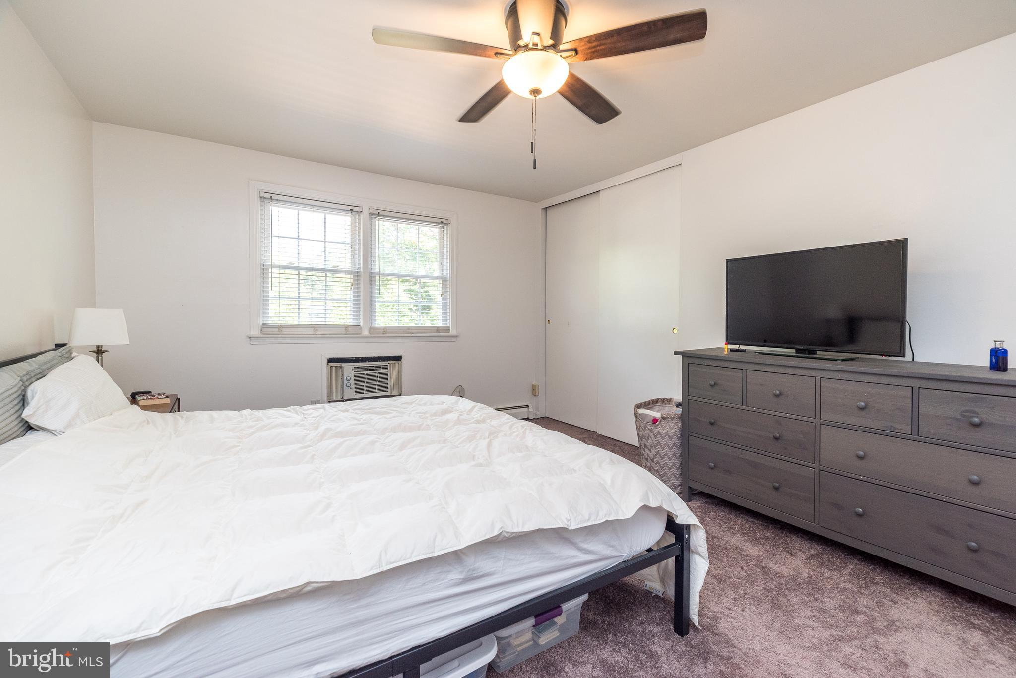 403 South Main Street, Unit C202 Doylestown, PA 18901 - Photo 14 of 18 a bedroom with a bed and a flat screen tv