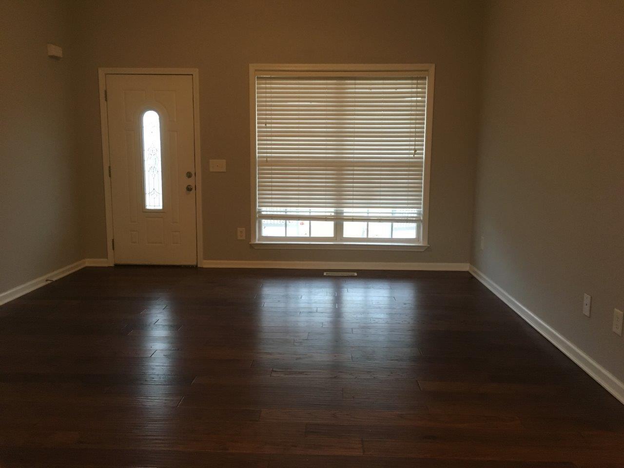 1009 Cameron Way Portland, TN 37148 - Photo 5 of 17 an empty room with wooden floor and windows