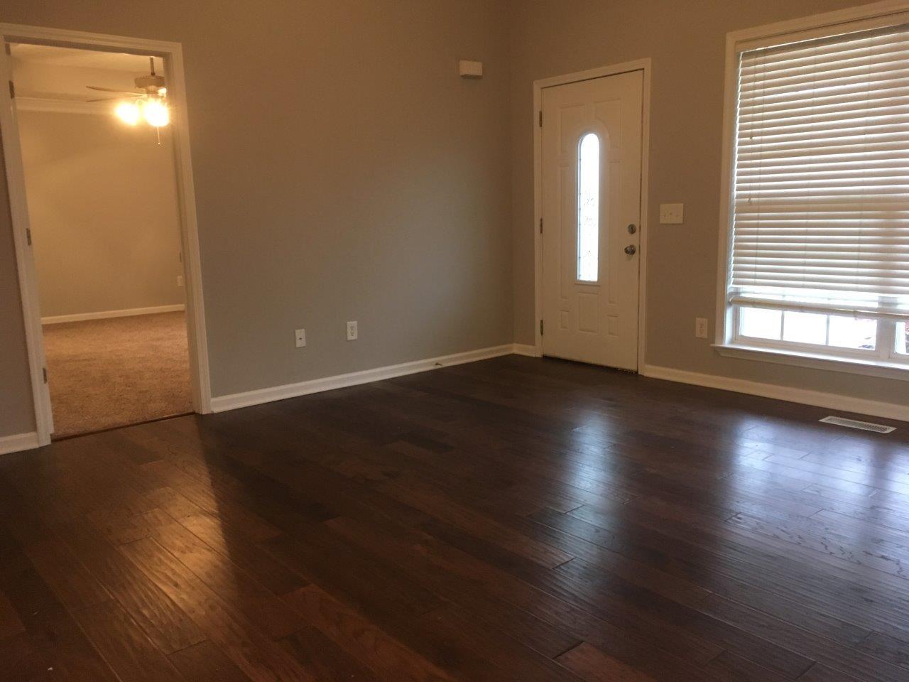 1009 Cameron Way Portland, TN 37148 - Photo 7 of 17 an empty room with wooden floor and windows