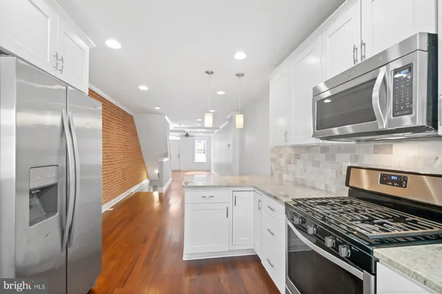 a kitchen with stainless steel appliances granite countertop a stove a sink and a refrigerator
