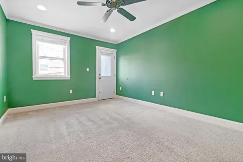 an empty room with a window and a ceiling fan