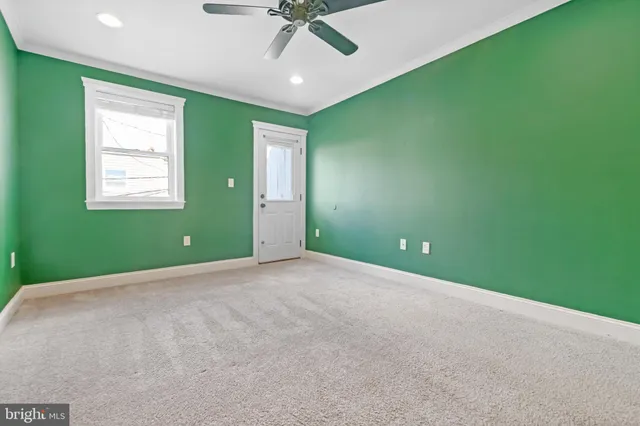 an empty room with a window and a ceiling fan