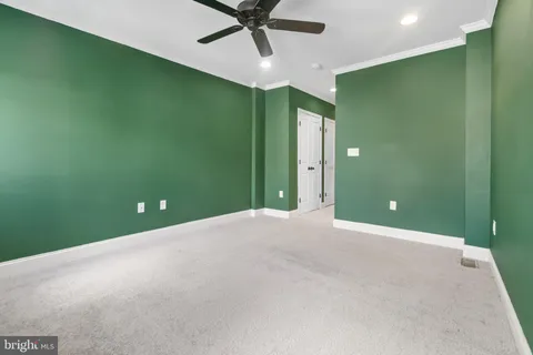 a view of a room with a projector and ceiling fan
