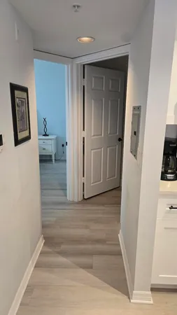a view of a hallway with wooden floor and furniture
