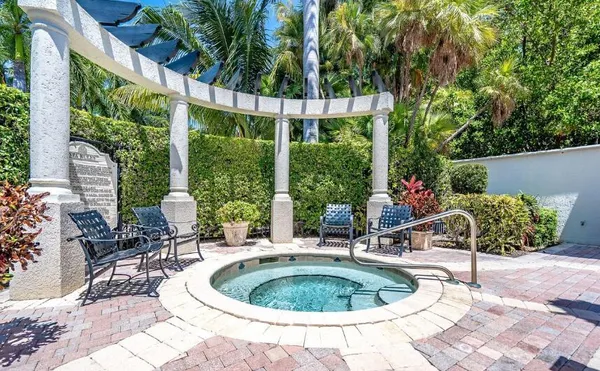 a swimming pool with outdoor seating and plants
