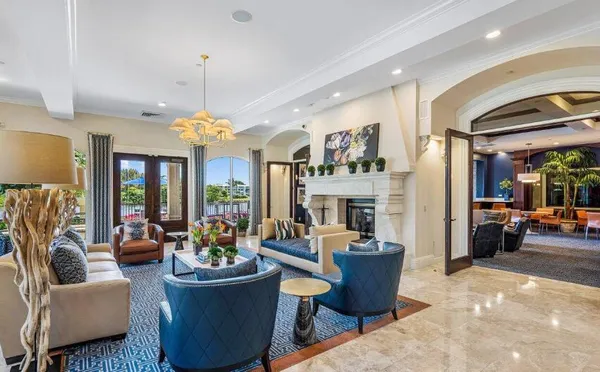 a living room with furniture a fireplace and a chandelier