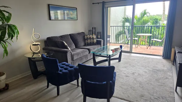 a living room with furniture and a floor to ceiling window