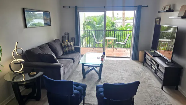 a living room with furniture a flat screen tv and a window