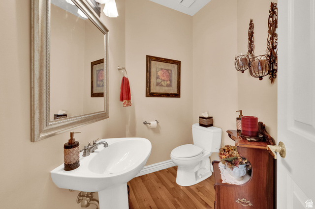 7740 Keswick Road Sandy, UT 84093 - Photo 16 of 74 Pedestal sink with chrome-finish faucet, framed mirror, light wood-finish flooring, and wall-mounted decorative sconces