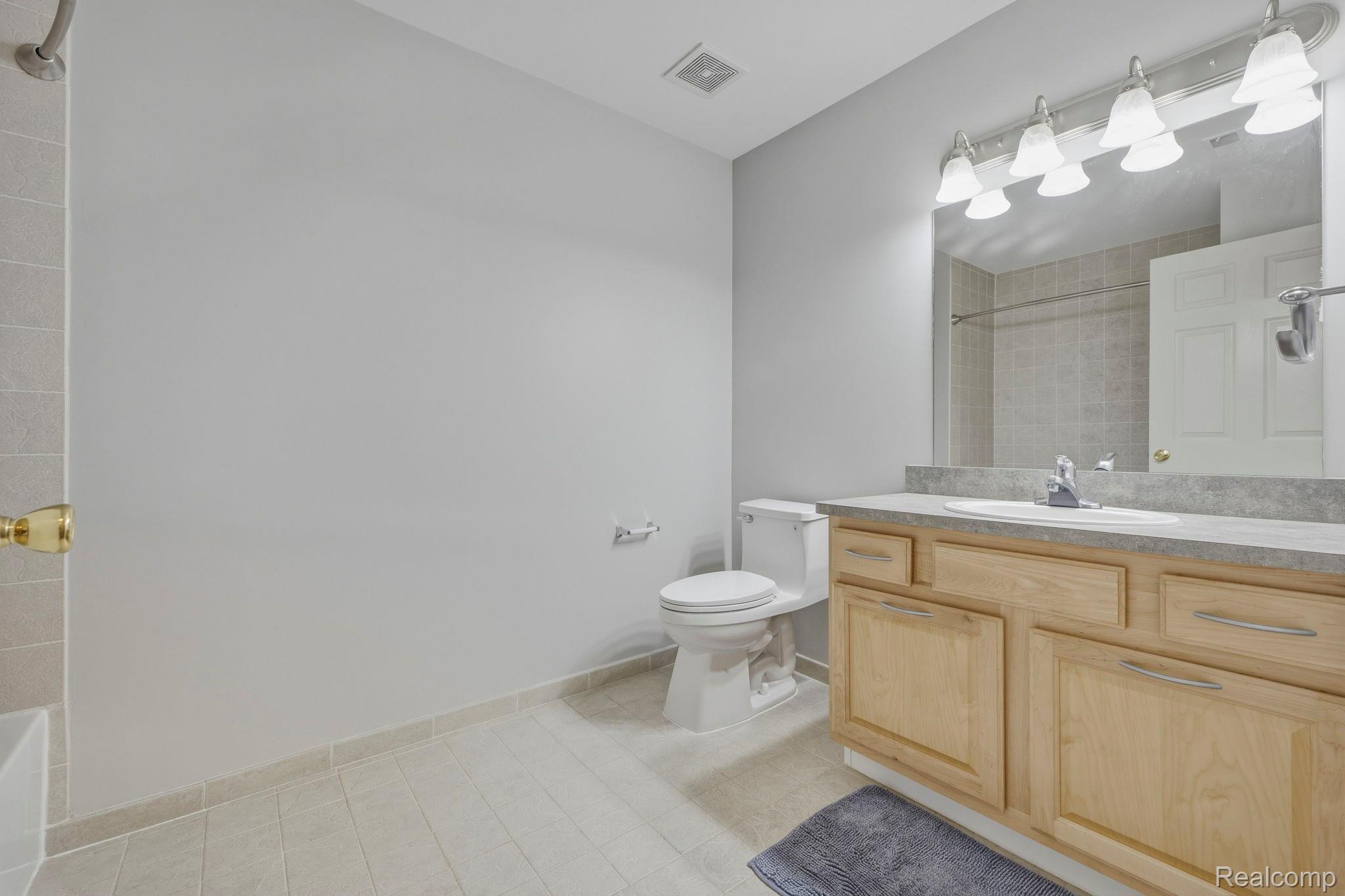 1905 Flagstone Circle Rochester, MI 48307 - Photo 26 of 33 Hard-surface flooring, light wood-finish vanity with ample storage, integrated sink, and a multi-bulb vanity light fixture