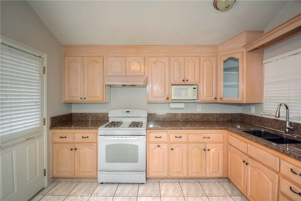 3446 Briarvale Street Corona, CA 92879 - Photo 11 of 37 a kitchen with granite countertop white cabinets sink and stainless steel appliances