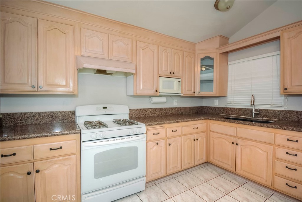 3446 Briarvale Street Corona, CA 92879 - Photo 10 of 37 a kitchen with granite countertop white cabinets white stainless steel appliances with a sink and dishwasher