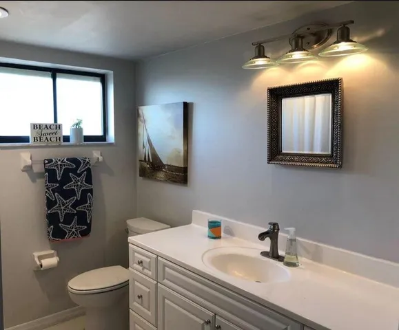 a bathroom with a sink a toilet and a mirror