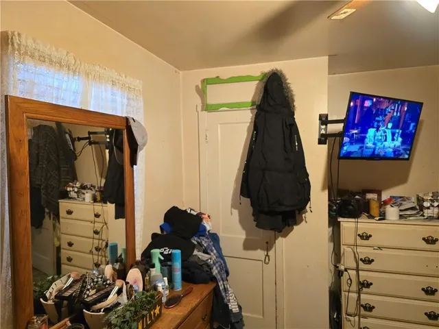 a view of a room with workspace and a chandelier fan